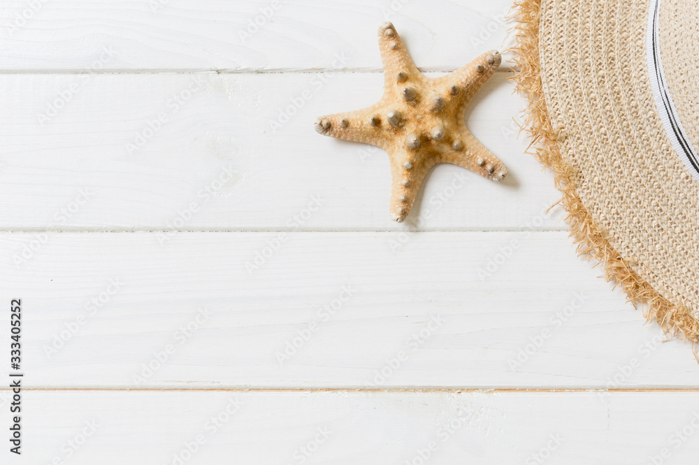 Straw hat and starfish On a white wooden background. top view summer holiday concept with copy space