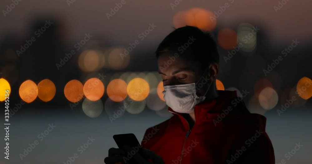 Man using smartphone with surgical mask in the evening city Man using smartphone with surgical mask in the evening city