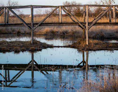 An old wood bridge and it s reflection.