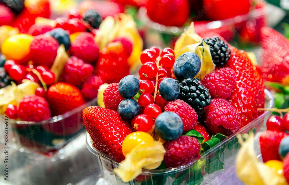 Varied assortment of fresh berries for dessert - raspberries, strawberries, blueberries, blackberry in a basket at a farmers market. Varied assortment of fresh berries for dessert - raspberries, strawberries, blueberries, blackberry in a basket at a farmers market.
