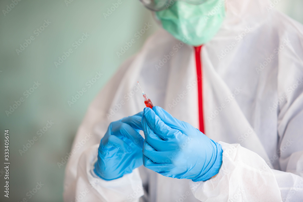 Fototapeta premium Doctors are searching for Covid's anti-virus serum by studying lung infection photos, protected by a mask and sanitary gloves.
