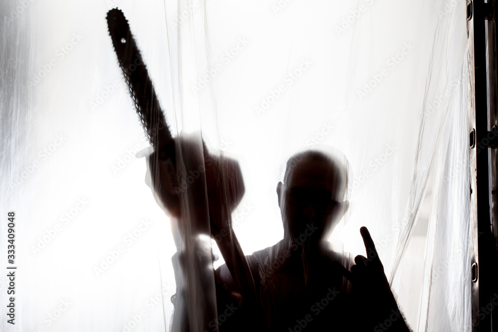 silhouette of man behind a plastic
