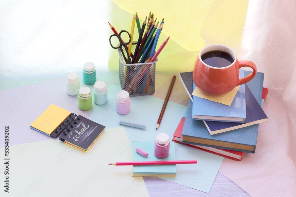 School stationery, books, cup of tea on the table, home schooling concept, part of the interior children's room, back to school School stationery, books, cup of tea on the table, home schooling concept, part of the interior children's room, back to school
