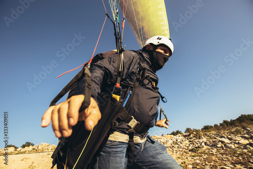 Active senior paraglider on the ground prepairs to fly.
