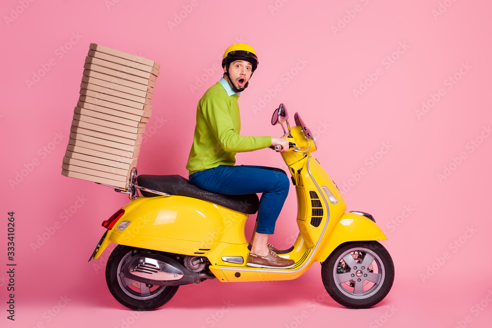 Profile side view of his he nice attractive funky worried busy guy driving moped bringing carrying pile stack pizza cafe cafeteria service isolated over pink pastel color background Profile side view of his he nice attractive funky worried busy guy driving moped bringing carrying pile stack pizza cafe cafeteria service isolated over pink pastel color background