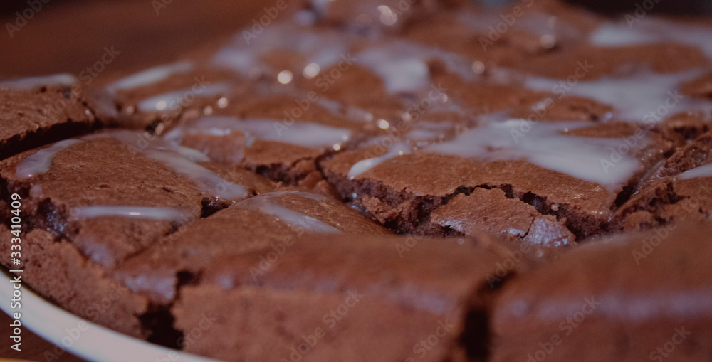 Chocolate brownie rests on a flat plate Chocolate brownie rests on a flat plate