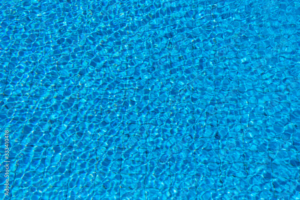 Pure Blue Water In The Swimming Pool. Ripple And Waves In Clear Turquoise Water. Glare And Reflection, Water Pool Surface Background. Aqua Texture, Backdrop. Pure Blue Water In The Swimming Pool. Ripple And Waves In Clear Turquoise Water. Glare And Reflection, Water Pool Surface Background. Aqua Texture, Backdrop.