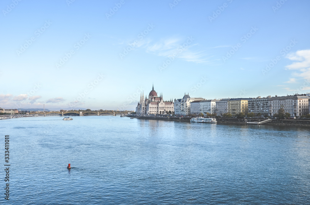 Fototapeta premium Danube river in Budapest, Hungary. Historical center with Hungarian Parliament building in the background by the river. Budapest cityscape with blue sky above. Eastern European cities