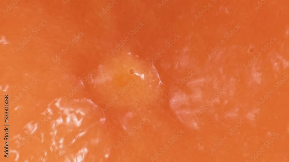 Orange smoothie is blending in blender with splashes, top view, close up, slow motion. Healthy eating concept. Orange smoothie is blending in blender with splashes, top view, close up, slow motion. Healthy eating concept.