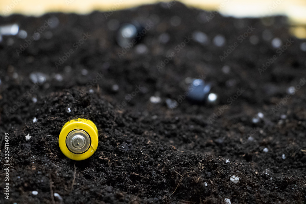 Used batteries in the ground. Hazardous waste polluting the environment. The concept of environmental protection and the recycling of batteries and batteries Used batteries in the ground. Hazardous waste polluting the environment. The concept of environmental protection and the recycling of batteries and batteries