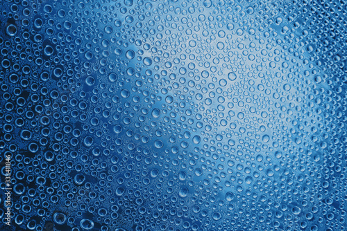 Condensate. Drops of water on a glass. Blue toned