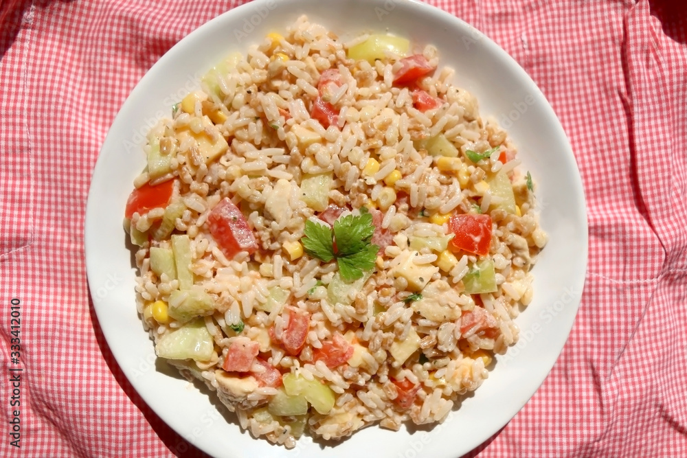 Salad with rice, chicken, cheese and vegetables. Top view.