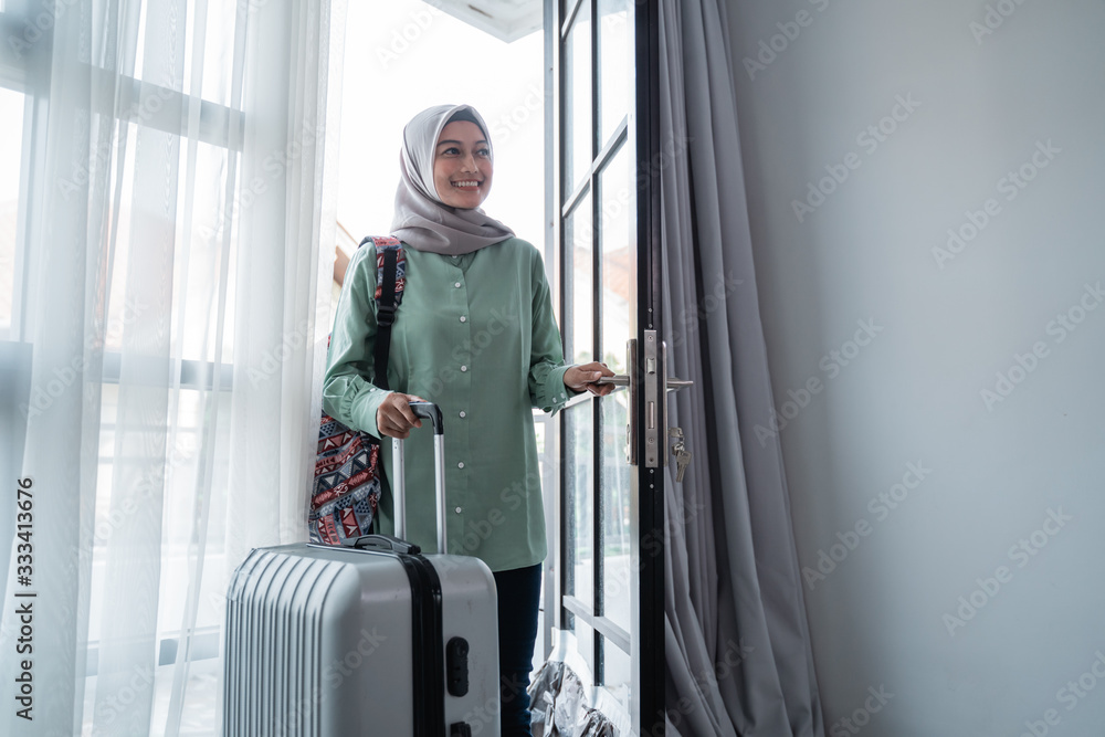 veiled young woman opened the door house with carrying her bag and suitcase after leaving for a long time veiled young woman opened the door house with carrying her bag and suitcase after leaving for a long time