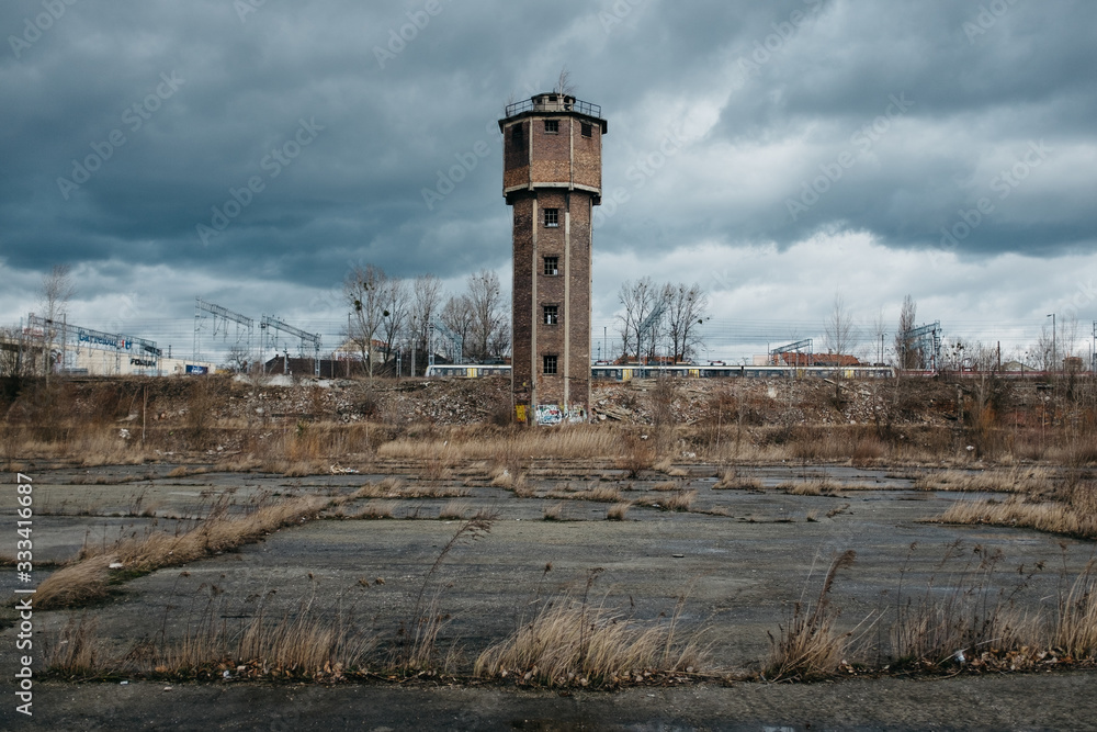 Obraz premium Old pressure tower with train in the background