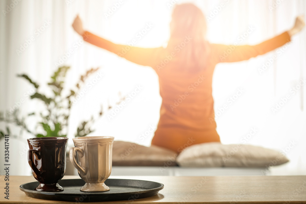 Woman by the window in the morning in the light of the sun Woman by the window in the morning in the light of the sun