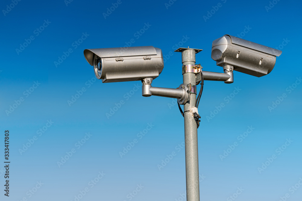 Security CCTV video camera against blue sky. Security CCTV video camera against blue sky.