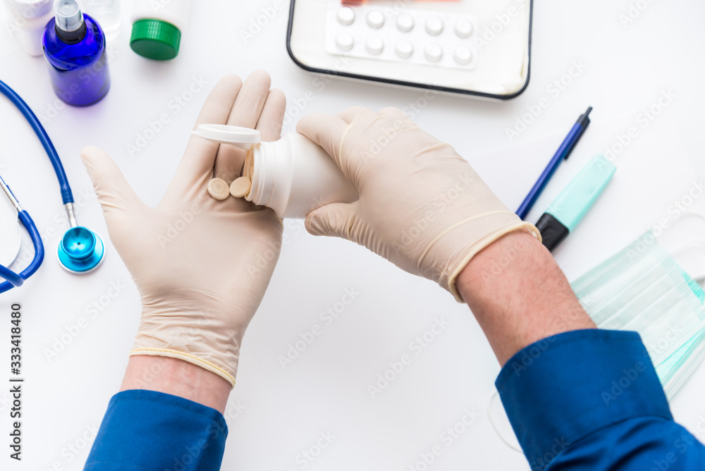 Fototapeta premium A man takes medications and vitamins, prevention and treatment of coronavirus