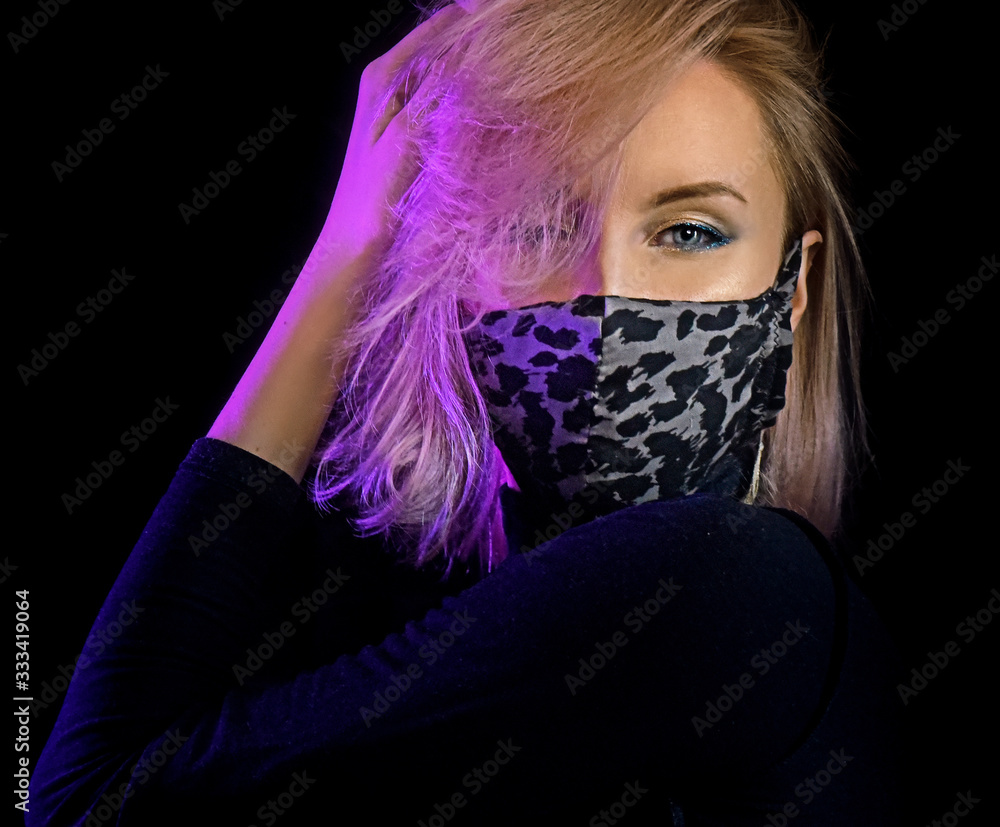 neon lights woman in surgical mask against coronavirus poses for