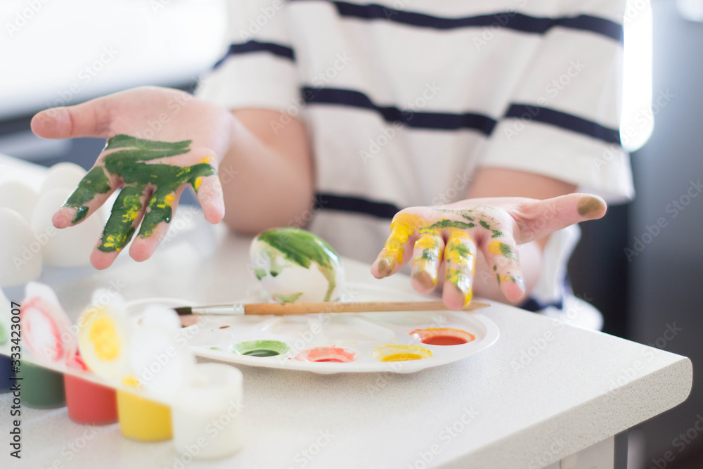 a child paints eggs with watercolors and gouache waits for Easter and plays a child paints eggs with watercolors and gouache waits for Easter and plays
