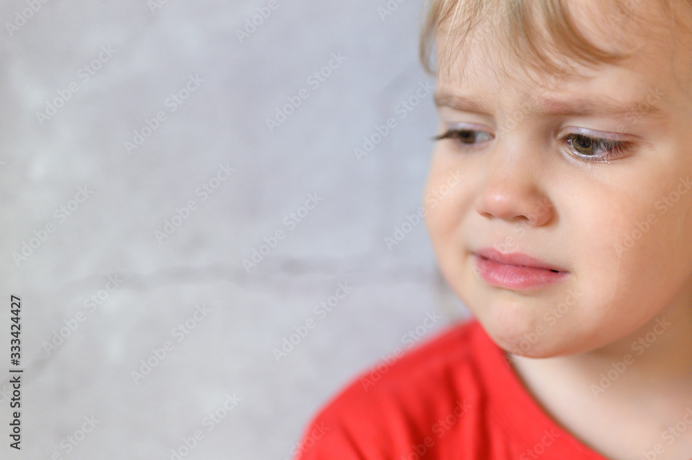 kid crying. the face of a cute little upset four year old baby boy in tears. children's grief. gray concrete wall background. space for text kid crying. the face of a cute little upset four year old baby boy in tears. children's grief. gray concrete wall background. space for text