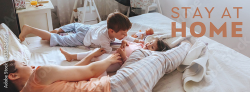 Portrait of happy family playing over the bed in a relaxed morning during virus confinement photo