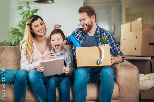 Happy family with cardboard boxes in new house at moving day.