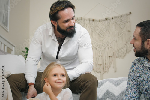 Same Sex Male Couple At Home. Fathers with daughter in bedroom