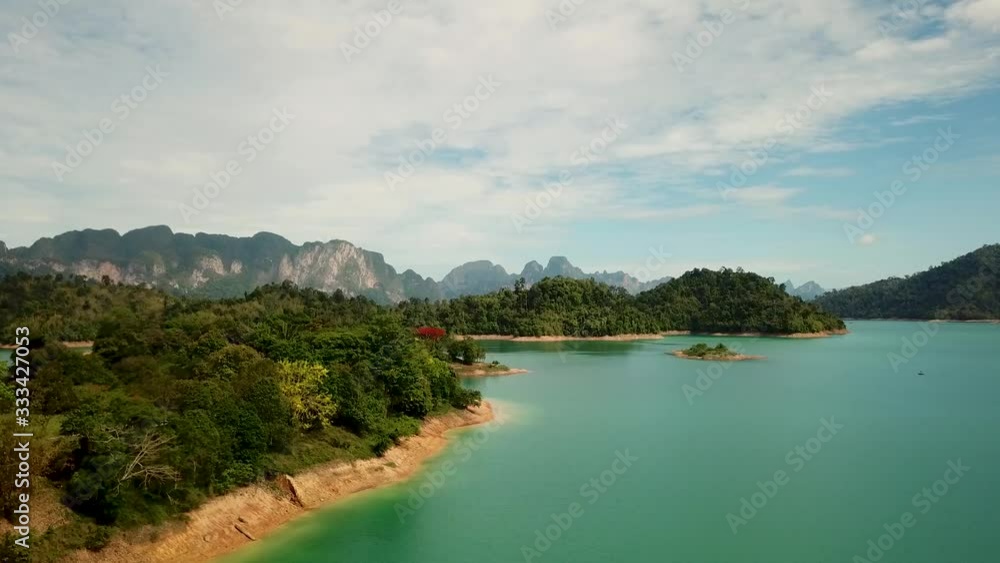 Aerial landscape of Cheow Lake in Khao Sok National Park in Thailand, turquoise water, small islands with trees and lime stone cliffs in the background Aerial landscape of Cheow Lake in Khao Sok National Park in Thailand, turquoise water, small islands with trees and lime stone cliffs in the background