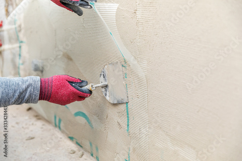 construction worker installing fiberglass plaster mesh on the wall photo