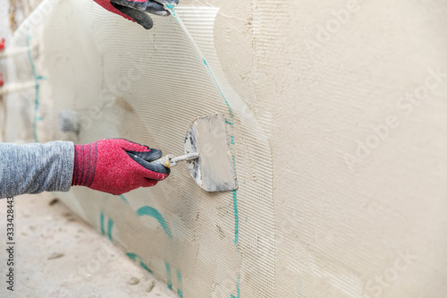 Fényképezés construction worker installing fiberglass plaster mesh on the wall