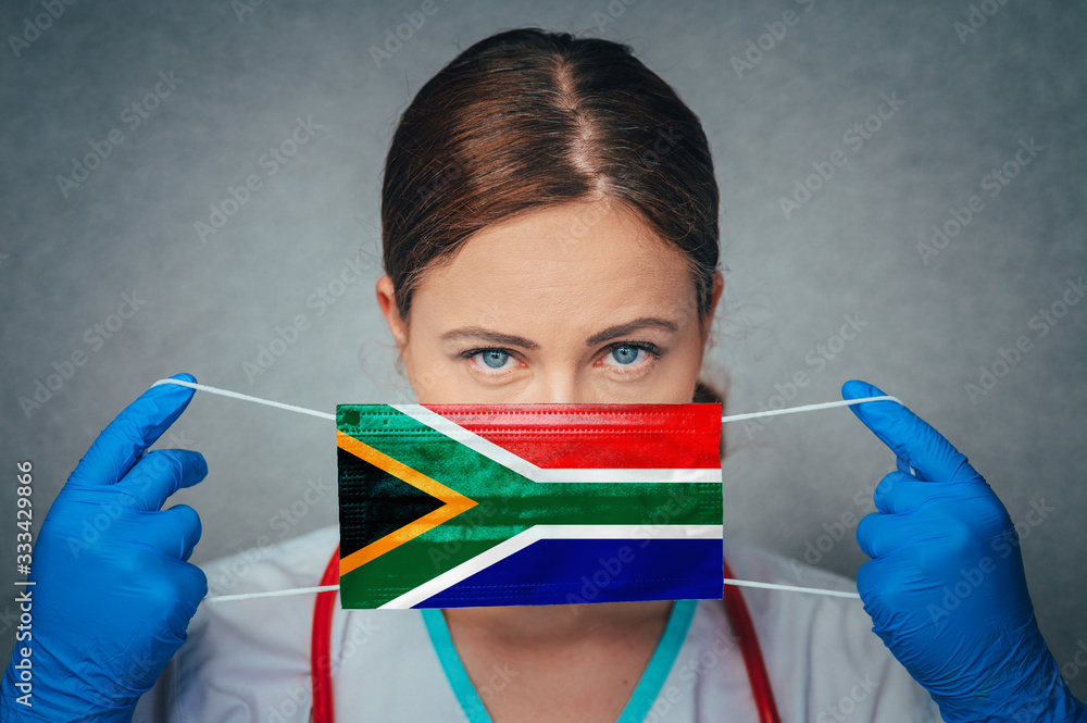 Coronavirus in South Africa Female Doctor Portrait hold protect Face surgical medical mask with South Africa National Flag. Illness, Virus Covid-19 in South Africa, concept photo - obrazy, fototapety, plakaty 