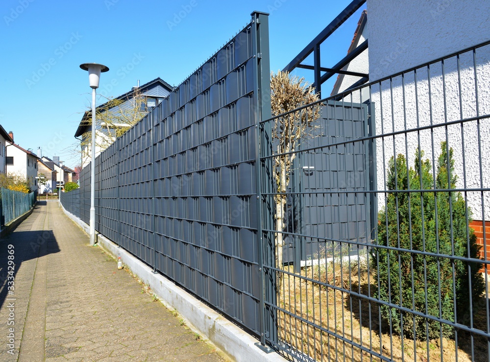 Abgrenzung eines Wohngrundstücks mit Kunststoff-Sichtschutzfolie an Stahlgitterzaun