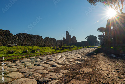 A stretch of the Via Appia, one of the most important streets of the Roman Empire photographed at first light in the morning. This road connected Rome to Brindisi, an important port in ancient Italy. photo