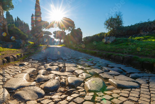 Fototapeta Naklejka Na Ścianę i Meble -  A stretch of the Via Appia, one of the most important streets of the Roman Empire photographed at first light in the morning. This road connected Rome to Brindisi, an important port in ancient Italy.
