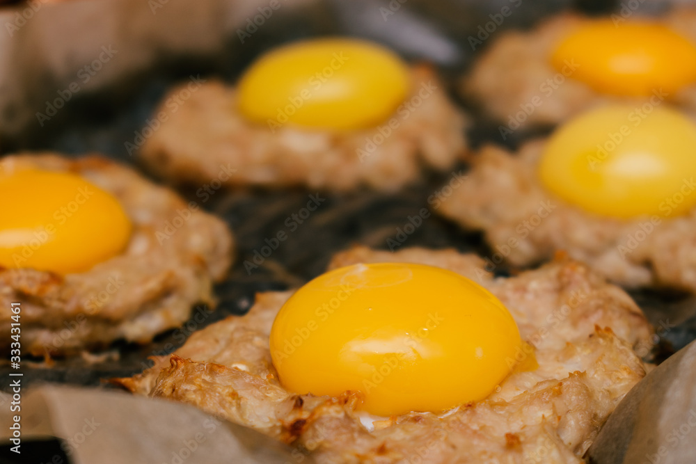 Raw egg on a cutlet close up before going to the oven.Idea for a healthy dinner.Concept ketogenic diet.Selective focus Raw egg on a cutlet close up before going to the oven.Idea for a healthy dinner.Concept ketogenic diet.Selective focus