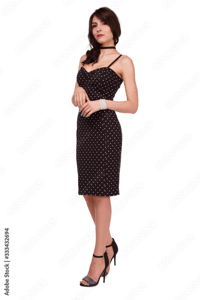 A beautiful, Caucasian brunette woman in a black tight-fitting dress stands on a white background in full growth. Isolate A beautiful, Caucasian brunette woman in a black tight-fitting dress stands on a white background in full growth. Isolate
