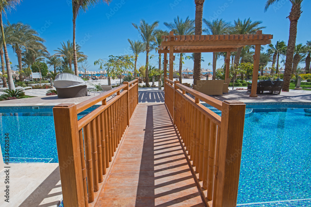 Wooden bridge over a swimming pool of luxury hotel resort room