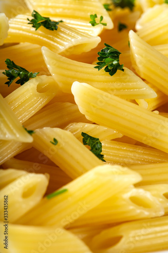 Boiled penne pasta with green chopped parsley