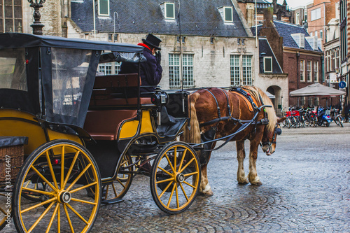 Empty Amsterdam, no one is on Dam Square-the historical center of Amsterdam. Horses as a transport for tourists. Tourism, urban travel concept.