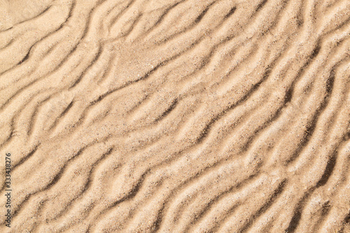Gold sand with abstract wave pattern. Sand texture background. Summer  and holiday concept.