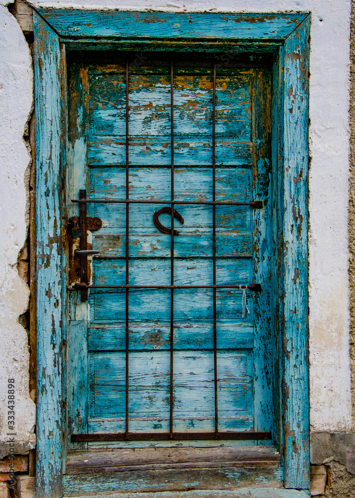 Naklejka premium old wooden blue door with the horse shoe in the middle