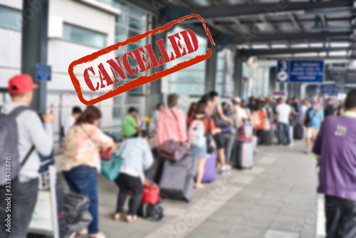 Blurred queue of travelers with their luggage waiting to fly and catch their transport after flight cancellation due to the coronavirus pandemic. Cancelled