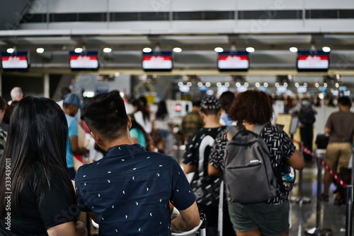 Anonymous queue of passengers in the queue waiting to arrive at the check-in desks of the airline company.