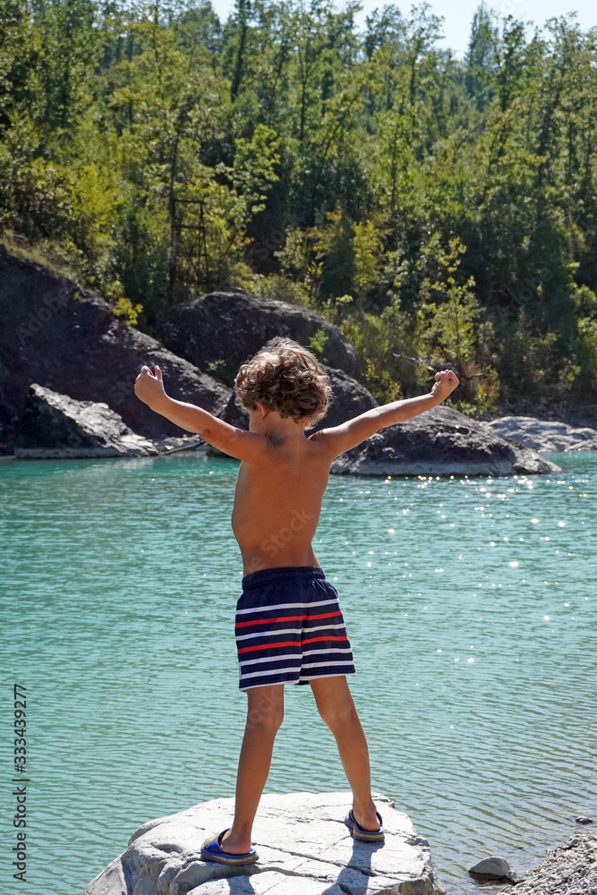 Fototapeta premium Europe, Italy , Piacenza, Bobbio - children five years old enjoy the nature in the river - summer and holidays during the n-cov19 Coronavirus epidemic 