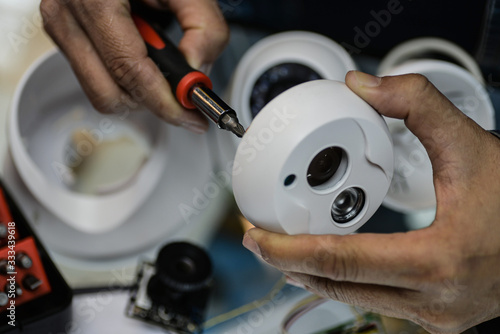technician repairs CCTV camera on the glass cabinet .