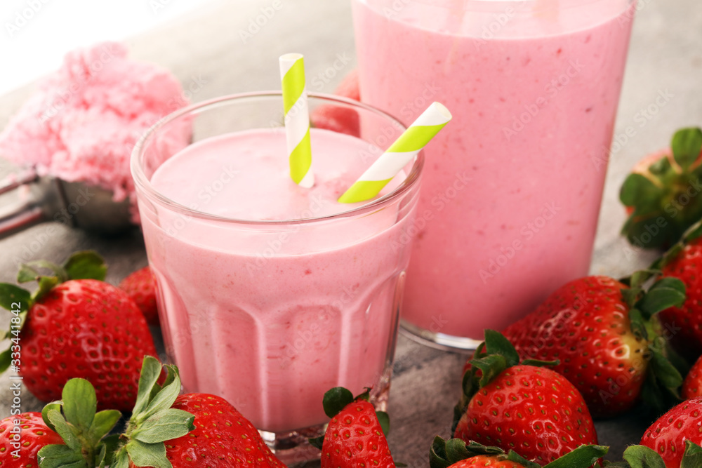 Glass of fresh strawberry shake, smoothie or milkshake and fresh strawberries on table. Healthy food and drink concept Glass of fresh strawberry shake, smoothie or milkshake and fresh strawberries on table. Healthy food and drink concept