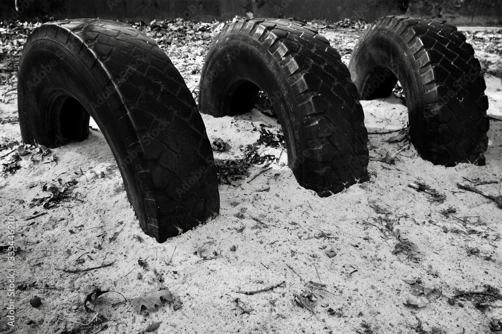 car tyres background buried in sand black and white 