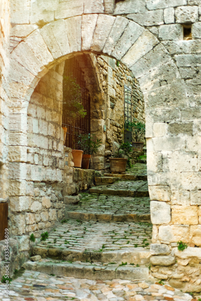 Vertical scenic landscape of old narrow arch way in one of the most beautiful villages of France Lacoste, Luberon, Vaucluse, Provence with traditional old stone houses. Travel tourism destination