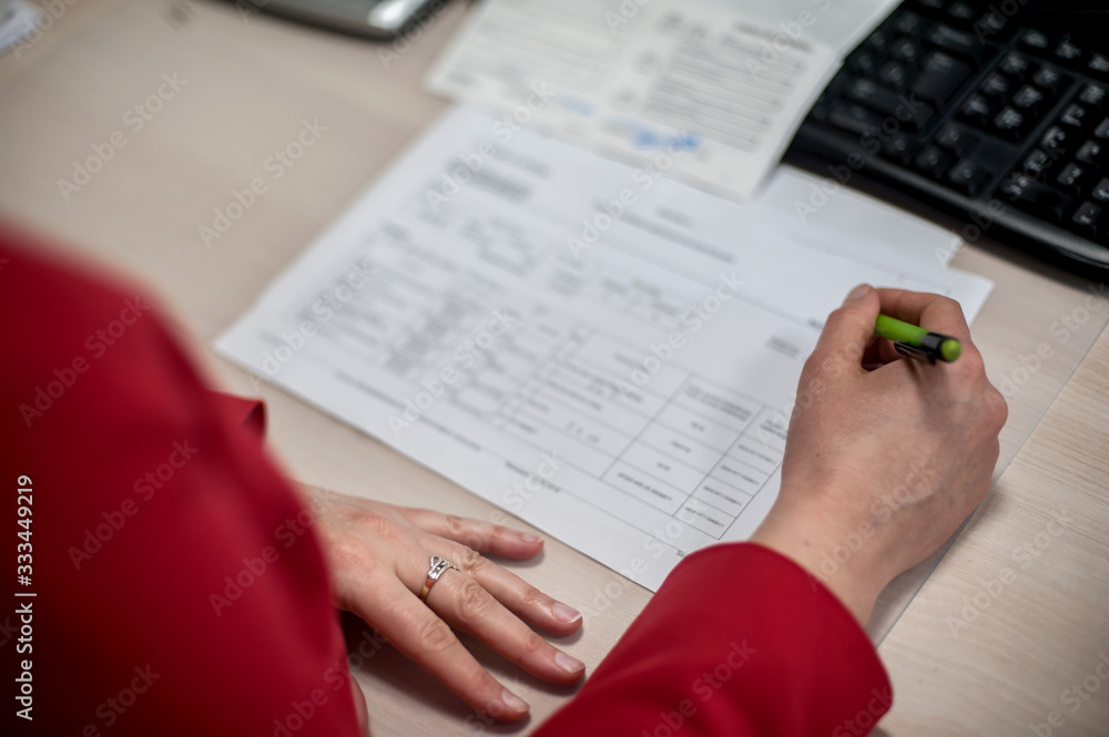 Fototapeta premium Close-up of female accountant hands, calculates and research the financial data position of the company and planning the economy financial profit or loss of bank accounts
