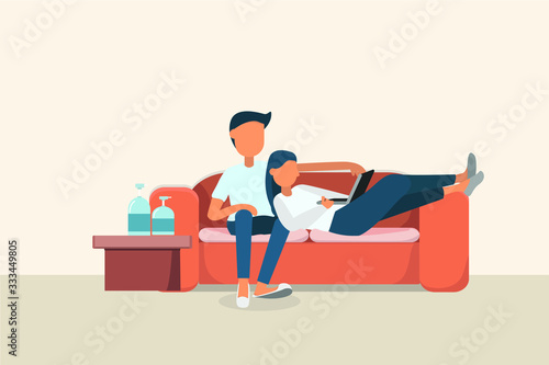 couple sitting on a sofa and look at a laptop